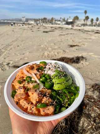 Delicious poke bowl eaten on a beach in San Diego