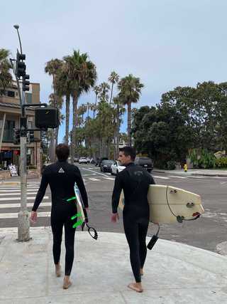 Surfers walking in the centre of at Pacific Beach
