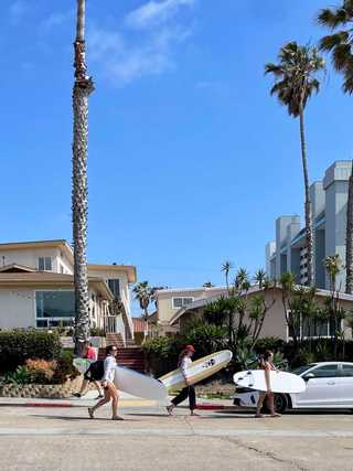Surfers carrying their surfboards at Pacific Beach