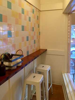 Pastel coloured tiles in a narrow corner of B-side Foods