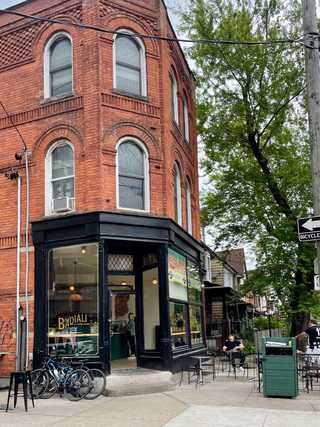 A local pizzeria located in an old red brick house with a street terrace