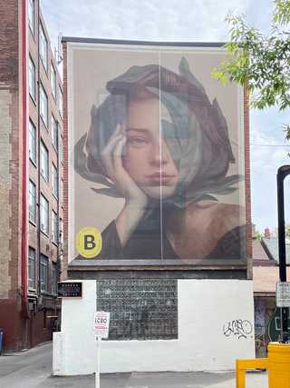 A serene mural of a face outside Boxcar Social