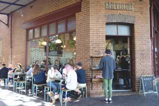People sitting in the sun outside a coffee shop