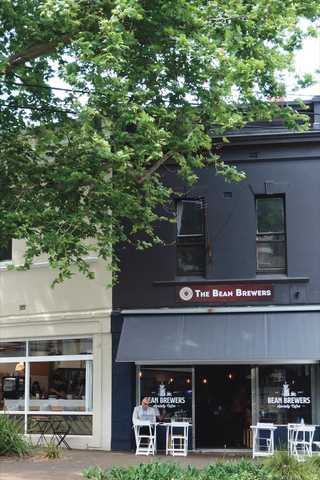 People sitting in the sun outside a coffee shop