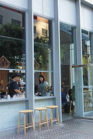 People sitting in the sun outside a coffee shop