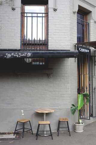 People sitting in the sun outside a coffee shop