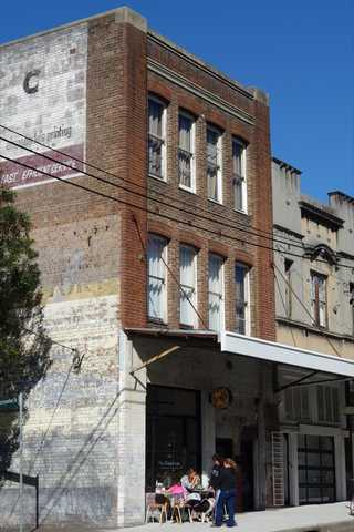 People sitting in the sun outside a coffee shop