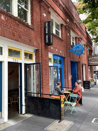 Patrons enjoying coffee and sunshine outside