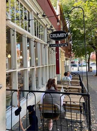 A leafy terrace and a big glass windows of the sandwich shop