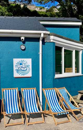Blue and white striped sunlounges against a blue cafe