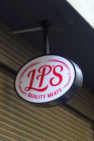 People sitting in the sun outside a coffee shop