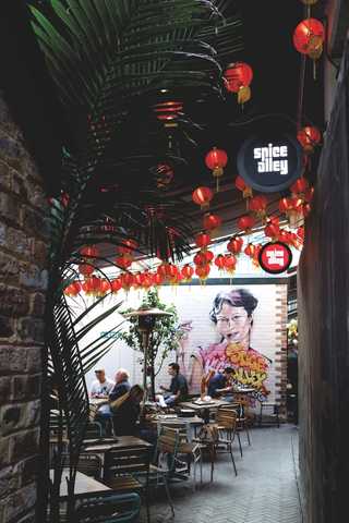 People sitting in the sun outside a coffee shop