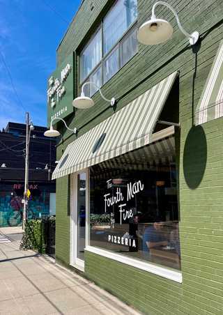 A green facade of a pizza restaurant