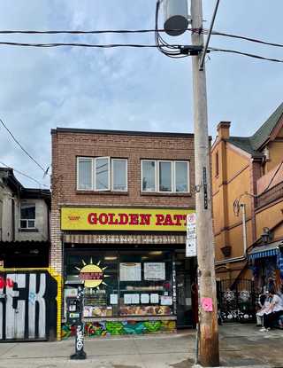 A humble looking local pastry shop against lots of graffiti