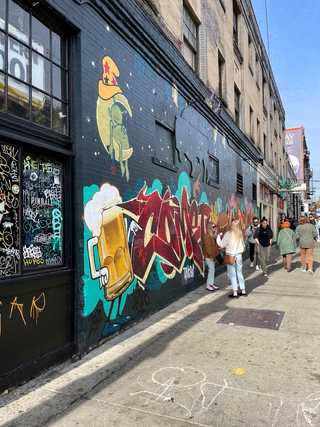 A graffiti of beer pints on a buzzing side street