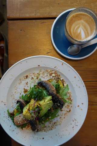 People sitting in the sun outside a coffee shop