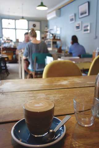 People sitting in the sun outside a coffee shop