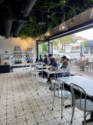 Patrons relaxing by a massive open window at La Clochette