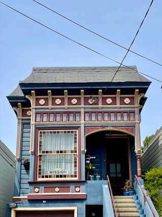 A vibrant tiny wooden house with a sign stating Mission