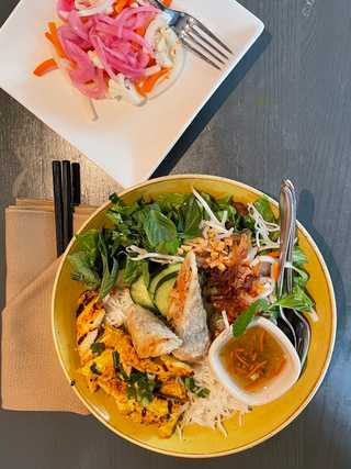 A delicious plate of noodles, chicken and spring rolls at Monsoon