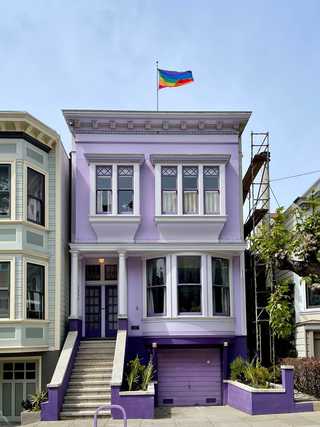 A vibrant purple house proudly waving a LGBT flag
