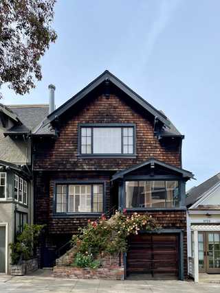 A beautiful shingles house with roses at the front