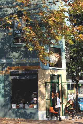 People sitting in the sun outside a coffee shop