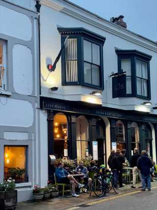 Cyclist having drinks outside a pub in Tenby