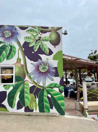 A large floral mural on the side of Wayfarer Bread and Pastry