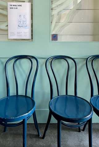 Three solitary turquise chairs waiting for patrons