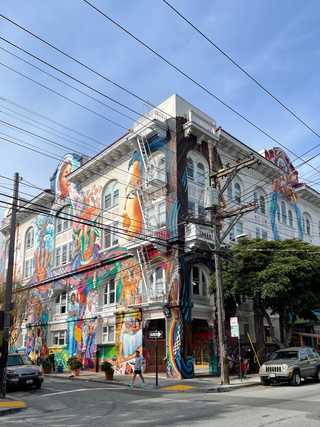 A huge building covered in graffiti of women of all ages